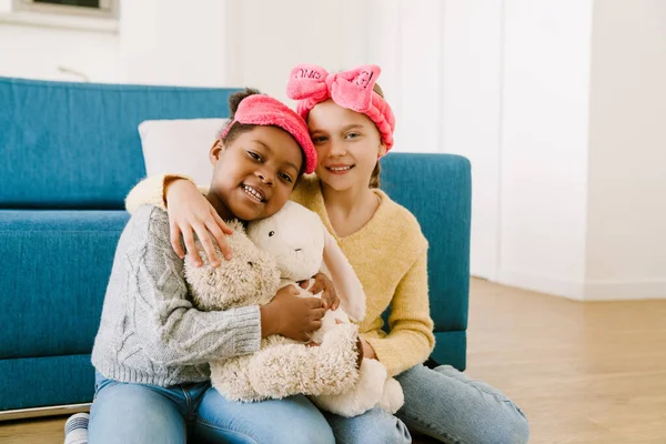 Küçük Mutlu Mutlu Irklar Arası Kız Kardeşler Evde Oyuncaklarla Sarılıp — Stok fotoğraf