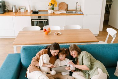 Beyaz kız ailesiyle evde vakit geçirirken tablet bilgisayar kullanıyor.