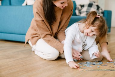 Beyaz sarışın kız, ailesiyle bulmacayı tamamlıyor.