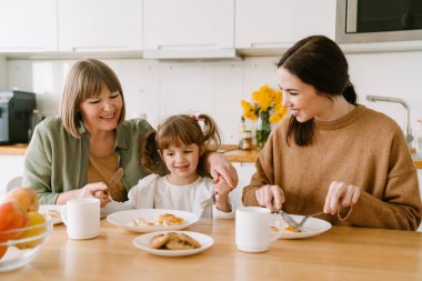Beyaz aile evde birlikte vakit geçirirken kahvaltı yapıyor.