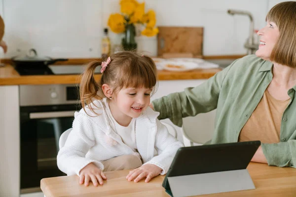 白人女孩在家里用平板电脑和奶奶呆在一起 — 图库照片