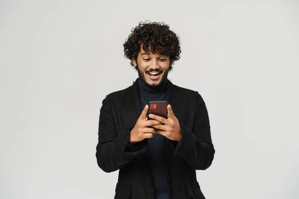 微笑的印度男人 在孤零零的灰色背景下 用手机看着自己 — 图库照片