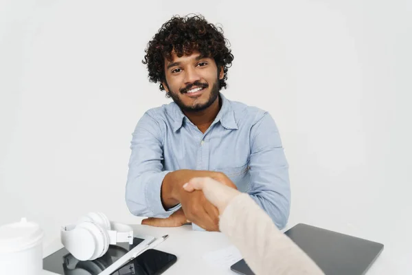 Pov Handshake Table Smiling Curly Indian Man Isolated Grey Background — Stock Photo, Image