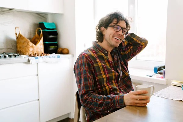 Hvit Mann Ler Drikker Kaffe Mens Han Sitter Kjøkkenet Hjemme – stockfoto