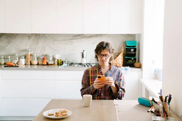 stock image White man using mobile phone while having breakfast at home