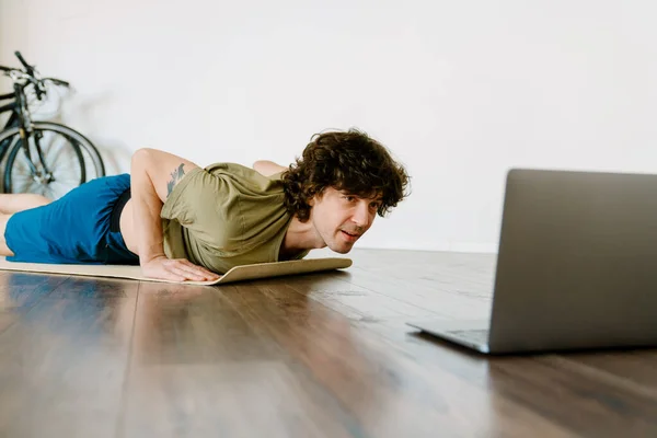 Bílý Muž Dělá Cvičení Během Jógy Praxe Notebookem Doma — Stock fotografie