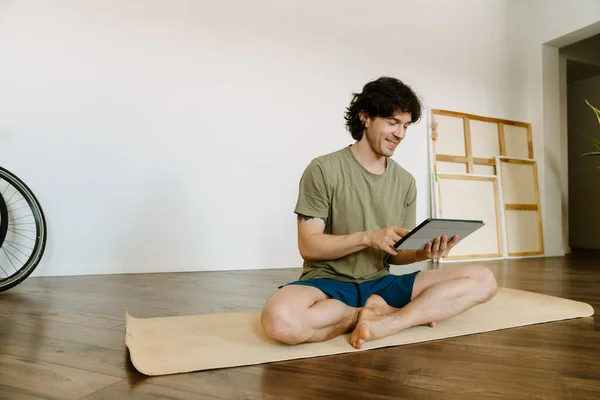 Bílý Muž Používající Tablet Během Cvičení Jógy Doma — Stock fotografie