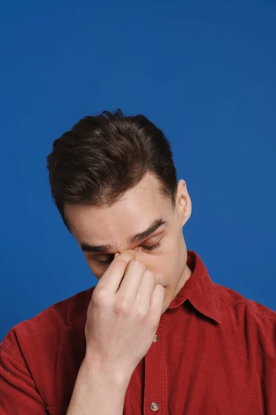 Νεαρός Κουρασμένος Άντρας Φοράει Πουκάμισο Κρατώντας Μύτη Του Ενώ Ποζάρει — Φωτογραφία Αρχείου