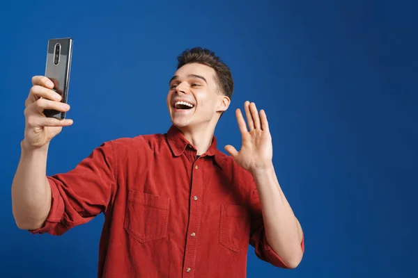 Genç Beyaz Adam Mavi Arka Planda Izole Edilmiş Cep Telefonuyla — Stok fotoğraf