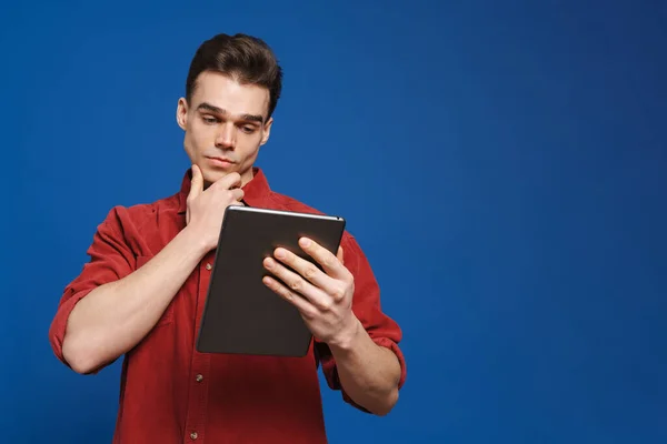 Mavi Arka Planda Izole Edilmiş Tablet Bilgisayar Kullanan Tişört Giyen — Stok fotoğraf