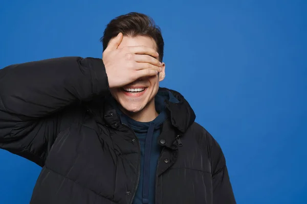 Młody Biały Mężczyzna Zakrywający Oczy Śmiejący Się Kamery Odizolowanej Niebieskim — Zdjęcie stockowe