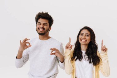 Genç Hintli çift gülerken birlikte hareket ediyor. Beyaz arka planda izole edilmiş.