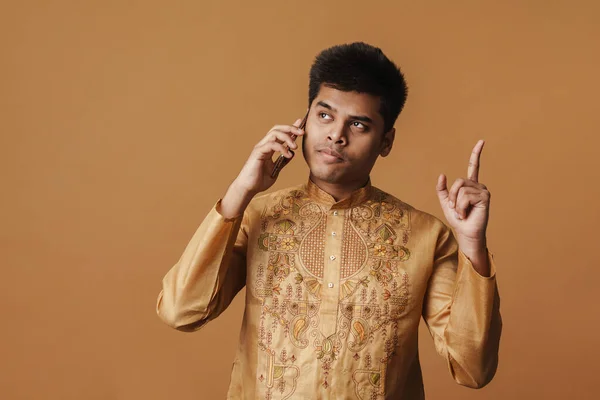 Молодая Брюнетка Индийский Мужчина Жесты Говорить Мобильному Телефону Изолированы Желтом — стоковое фото