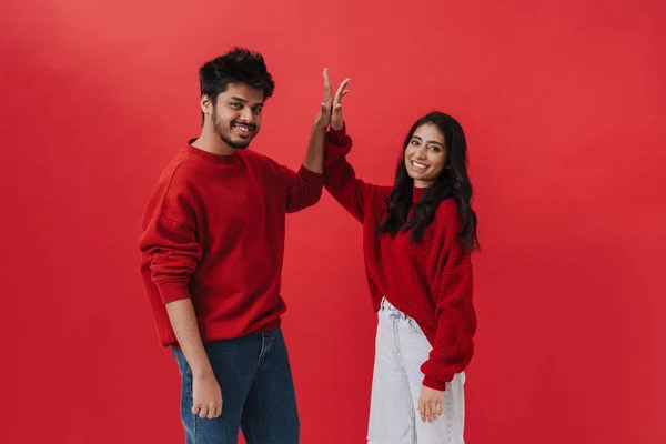 Genç Hintli Çift Gülerken Kırmızı Arka Planda Izole Edilmiş Beşlik — Stok fotoğraf