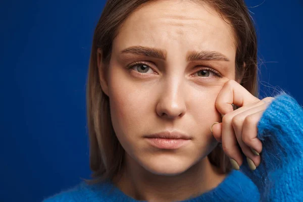 Gözyaşlarını Silen Genç Bir Kadın Mavi Bir Arka Planda Ağlarken — Stok fotoğraf
