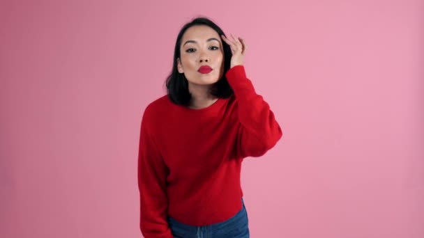 Mujer Asiática Sonriente Con Suéter Rojo Mirando Cámara Estudio Rosa — Vídeo de stock