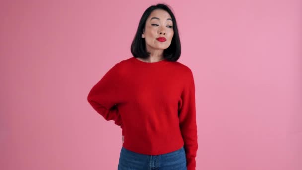 Mujer Asiática Sonriente Con Suéter Rojo Mirando Cámara Estudio Rosa — Vídeos de Stock