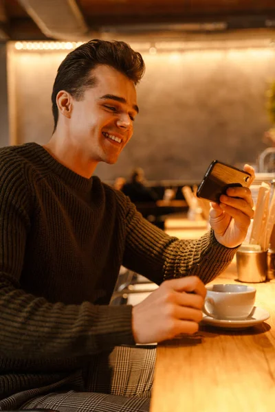 Süveter Giyen Cep Telefonu Kullanan Kafede Kahve Içen Genç Mutlu — Stok fotoğraf
