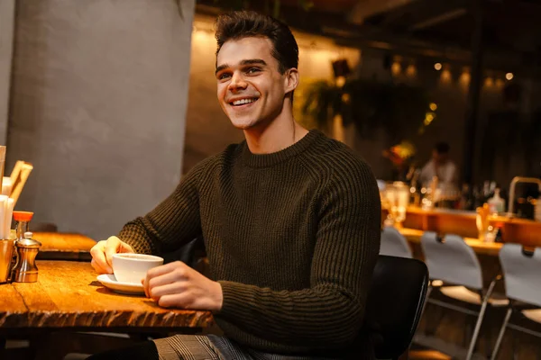 Kafede Kahve Içerken Gülümseyen Esmer Genç Bir Adam — Stok fotoğraf