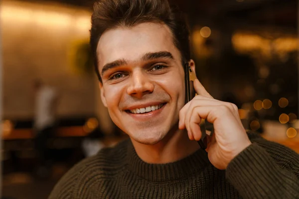 Kafede Cep Telefonuyla Konuşurken Gülümseyen Esmer Genç Bir Adam — Stok fotoğraf