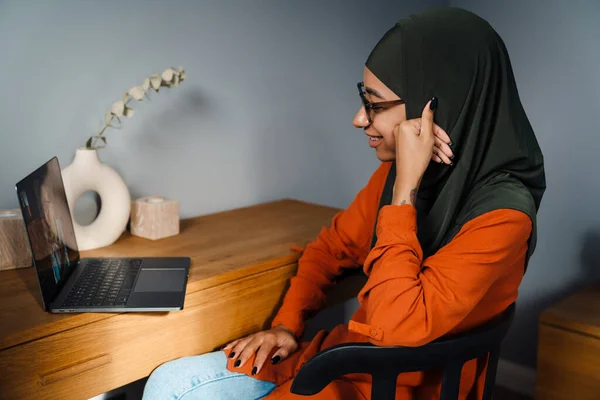 Młoda Kobieta Hidżabie Okulary Trzymając Wideokonferencji Siedzi Przytulnym Pokoju Domu — Zdjęcie stockowe