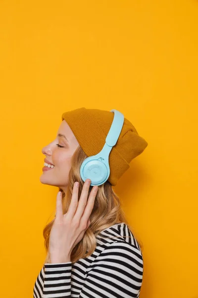 Ung Blond Kvinna Bär Hatt Leende Medan Lyssnar Musik Isolerad — Stockfoto