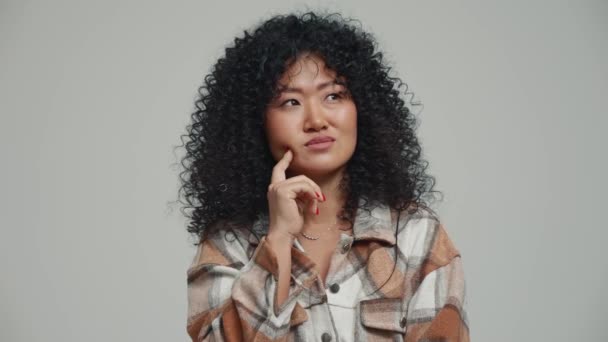 Pensive Brunette Asian Woman Thinking Something Grey Studio — Vídeos de Stock