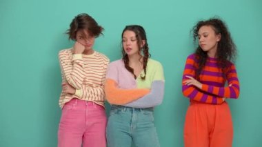 Three bored young girls thinking about something in the turquoise studio