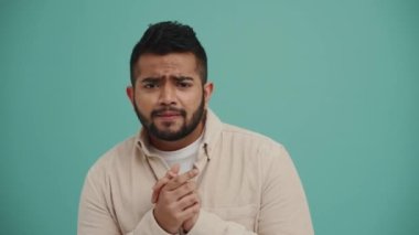 Endişeli Orta Doğulu genç hayran turkuaz stüdyoda zafere seviniyor.