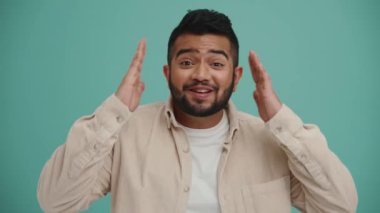 Turkuaz stüdyoda kamerayla konuşan Orta Doğulu genç adam şaşırdı.