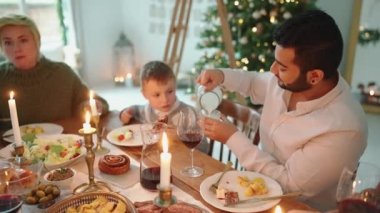 Noel 'i kutlayan ve evde konuşan dost canlısı çok kültürlü bir aile.