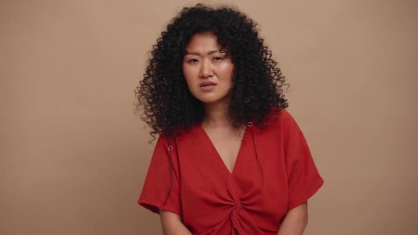 Surprised Curly Haired Asian Woman Looking Camera Beige Studio — Stock videók