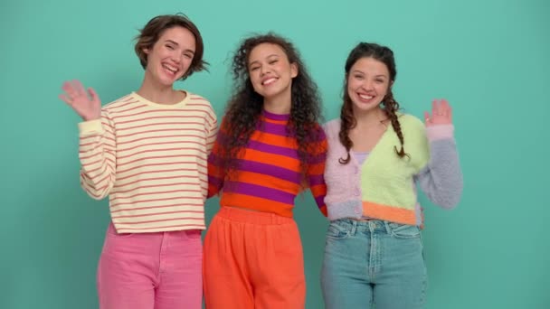 3人の笑顔若い女の子抱擁と手を振ってカメラでザターコイズスタジオ — ストック動画