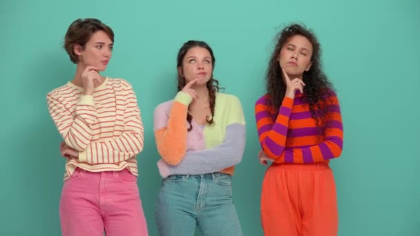 Three Pensive Young Girls Thinking Something Turquoise Studio — Stockvideo