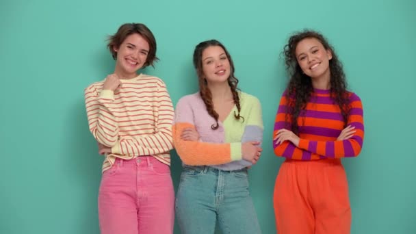 Три Усміхнені Молоді Дівчата Погоджуються Чимось Камері Бірюзовій Студії — стокове відео