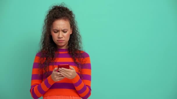 Displeased Young Curly Haired Woman Texting Smartphone Turquoise Studio — Stockvideo