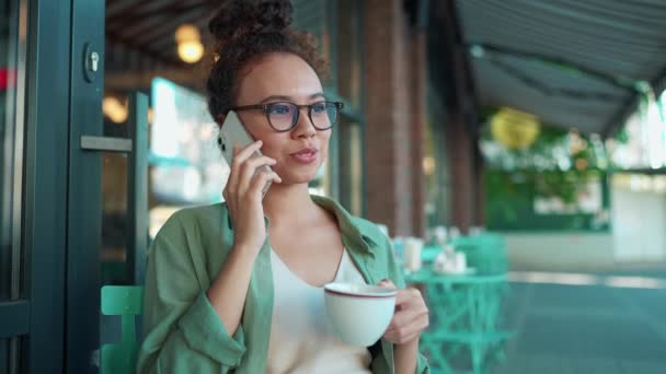 Rindo Mulher Africana Vestindo Óculos Falando Telefone Beber Café Café — Vídeo de Stock