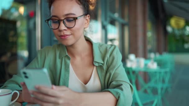 Positive African Woman Wearing Green Shirt Eyeglasses Texting Smartphone Cafe — Vídeos de Stock