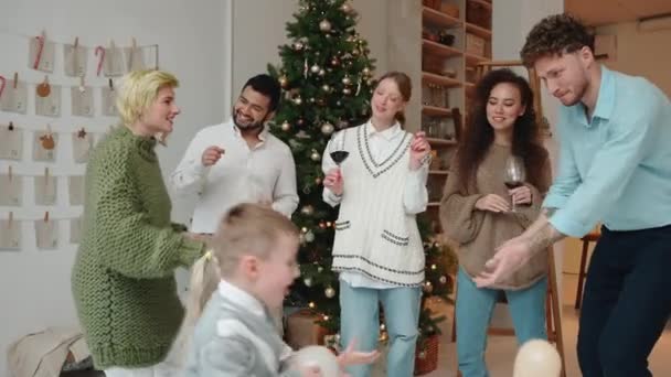 Θετικοί Πολυεθνικοί Φίλοι Γιορτάζουν Χριστούγεννα Και Χορεύουν Κοντά Στο Χριστουγεννιάτικο — Αρχείο Βίντεο