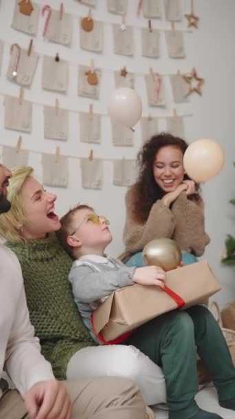 Γελώντας Διεθνείς Φίλους Γιορτάζει Χριστούγεννα Και Κοιτάζοντας Μπαλόνια Στο Σπίτι — Αρχείο Βίντεο