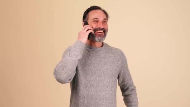 Захоплений Дорослий Бородатий Чоловік Сірому Светрі Говорить Мобільному Телефоні Бежевій — стокове відео