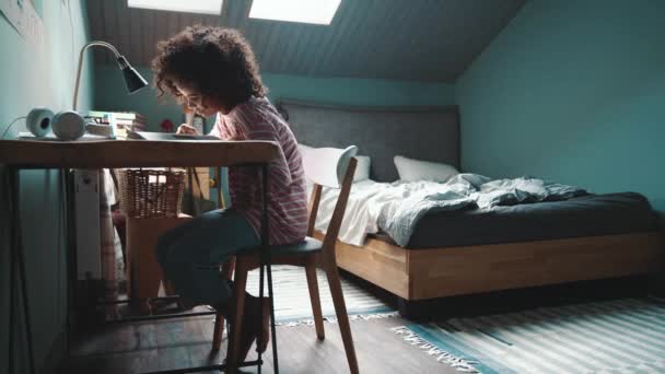 Concentrated Curly Haired Young African Girl Does Her Homework Home — Stockvideo