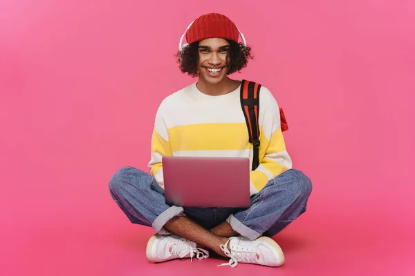 Young Caribbean Man Headphones Smiling Using Laptop Isolated Pink Background — Stok fotoğraf