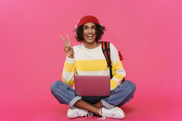 Young Caribbean Man Headphones Gesturing Using Laptop Isolated Pink Background — 图库照片