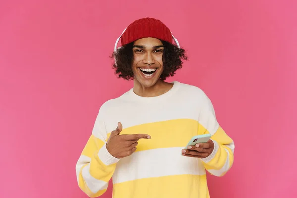 Young Caribbean Man Headphones Pointing Finger His Cellphone Isolated Pink — 图库照片
