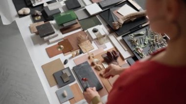 Overhead view of female architect puts samples on a table in the office