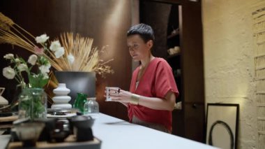 Concentrated female architect with short hair drinking tea in the office