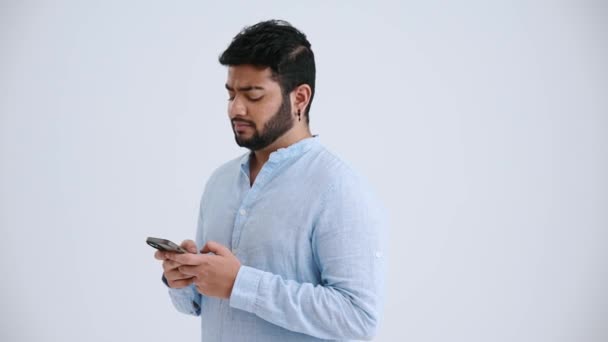 Pensive Indian Man Piercing Wearing Blue Shirt Typing Mobile Looking — Stock Video