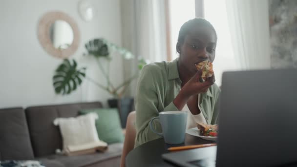 Concentrated African Woman Pigtails Watching Something Laptop Eating Toast Breakfast — Vídeo de Stock