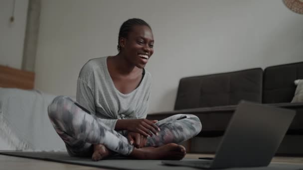 笑顔アフリカの女性とともにピグテールビデオ通話でノートパソコン上のマットで自宅 — ストック動画